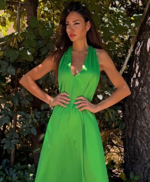 Μια γυναίκα με ένα πράσινο μακρύ σατέν φόρεμα