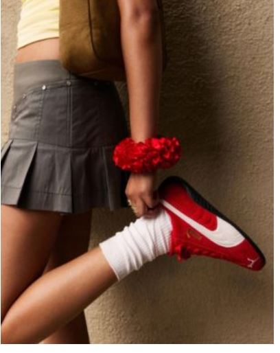 Γυναίκα με μίνι φούστα με κόκκινα αθλητικά παπούτσια