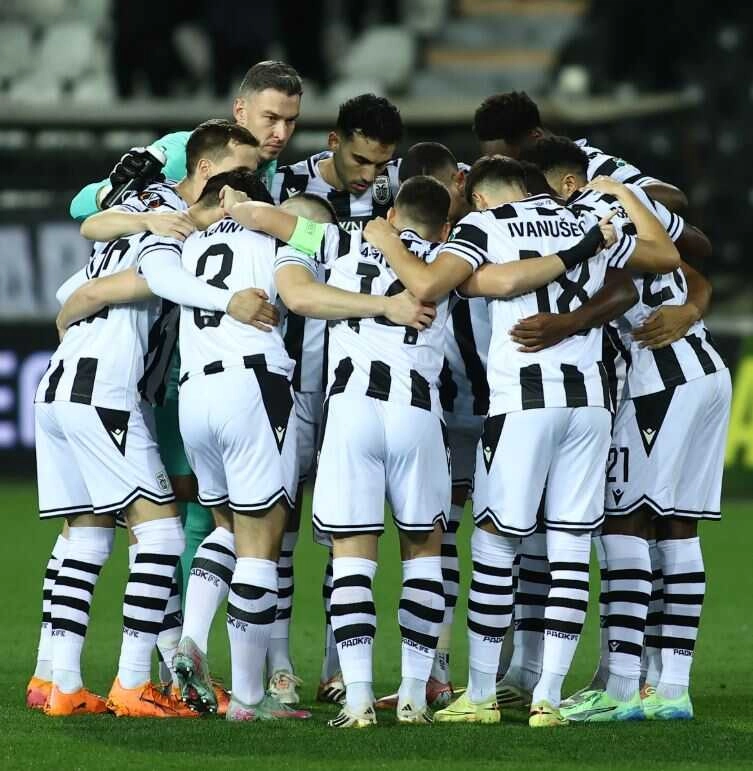 Οι ποδοσφαιριστές αγκαλιάζονται σε κύκλο στο γήπεδο