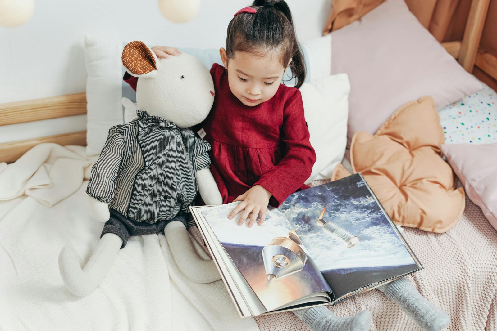 Ένα παιδί διαβάζει ένα βιβλίο με ένα λούτρινο ζωάκι